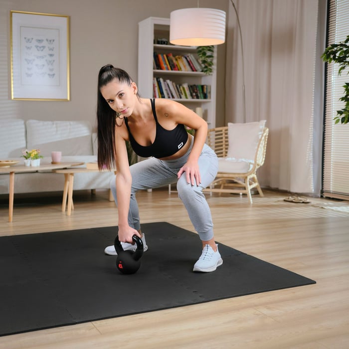 Femme s’entraînant avec kettlebells 6 kg Hop-Sport à domicile
