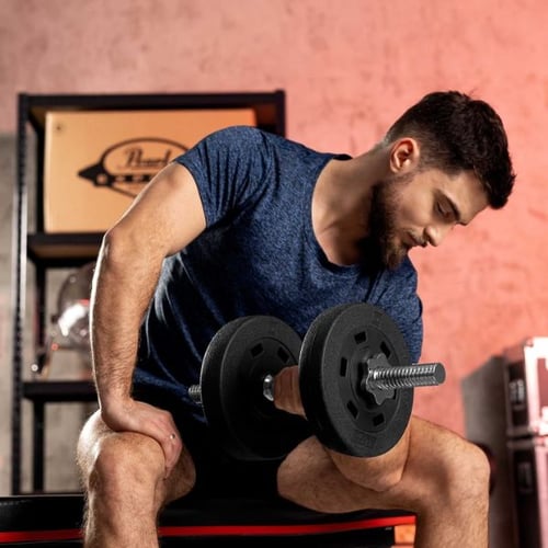 Un homme travaille ses triceps en utilisant un gros haltère Hop-Sport.