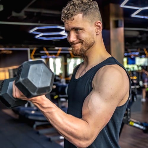 Un homme entraîne ses triceps en utilisant un altère.