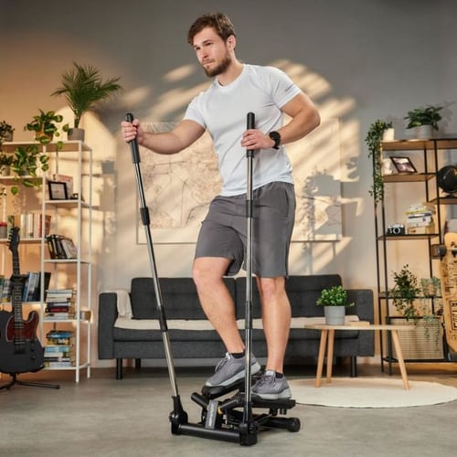 Un homme s'entraîne sur un stepper avec poignées en sollicitant les muscles du bas et du haut du corps