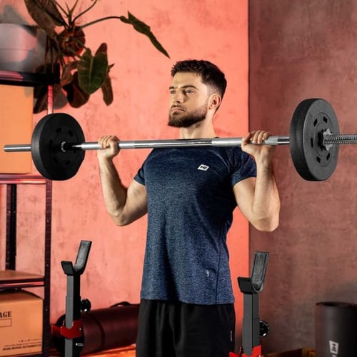 Un homme effectue un développé debout avec une barre classique de la marque Hop-Sport.