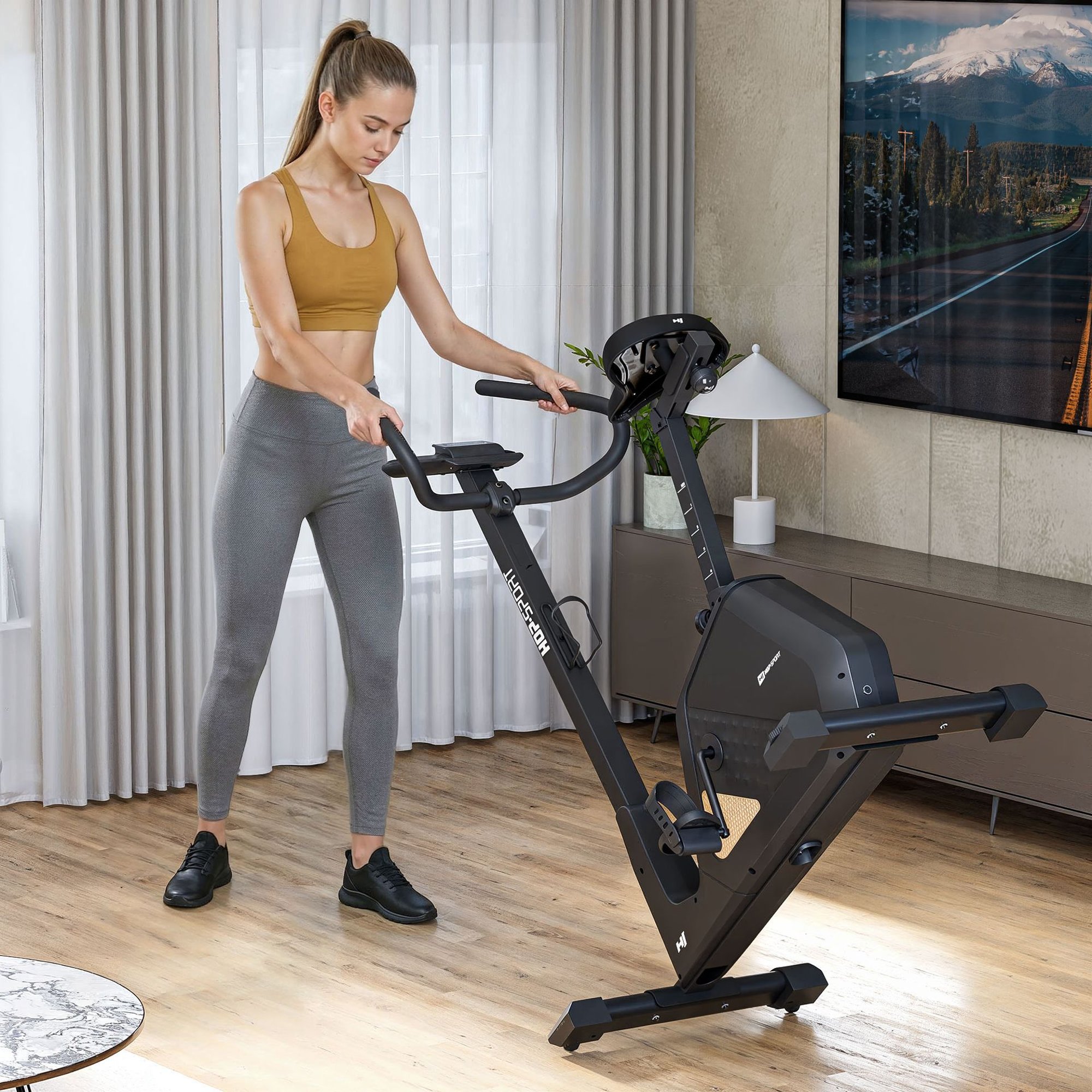 Vélo fitness compact avec roulettes de transport pour un déplacement facile.