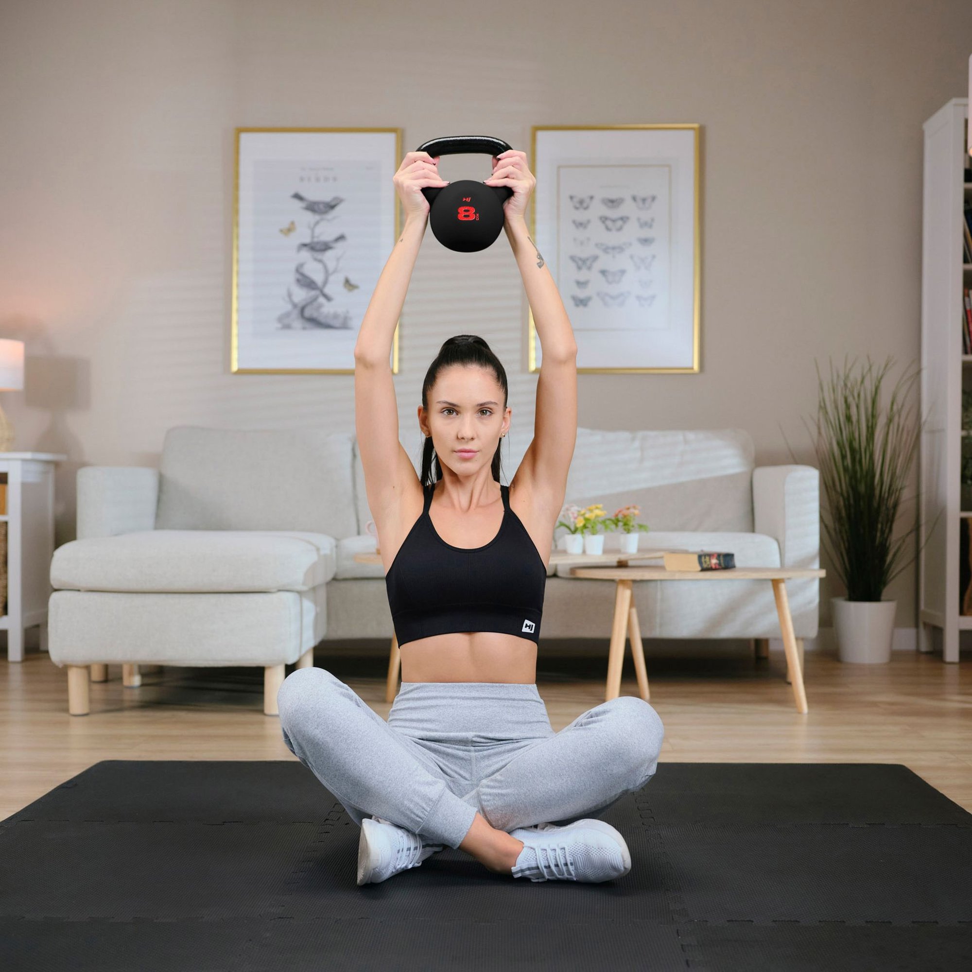 Femme s’entraînant avec kettlebells Hop-Sport à domicile