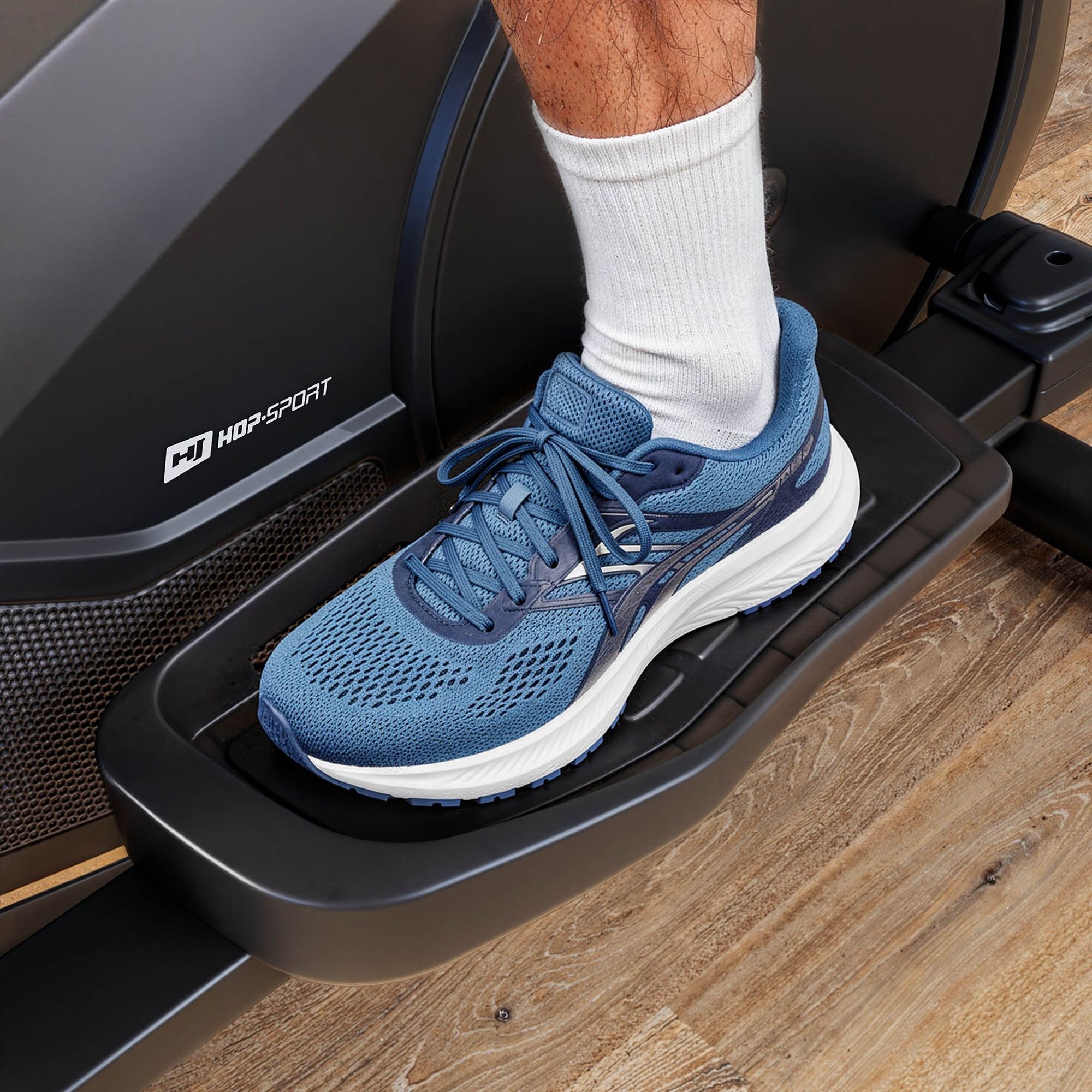 Repose-pieds antidérapants et porte-bouteille sur vélo elliptique robuste.