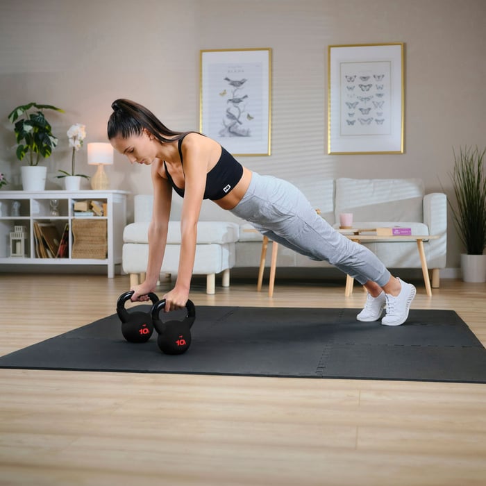 Femme s’entraînant avec kettlebells Hop-Sport à domicile